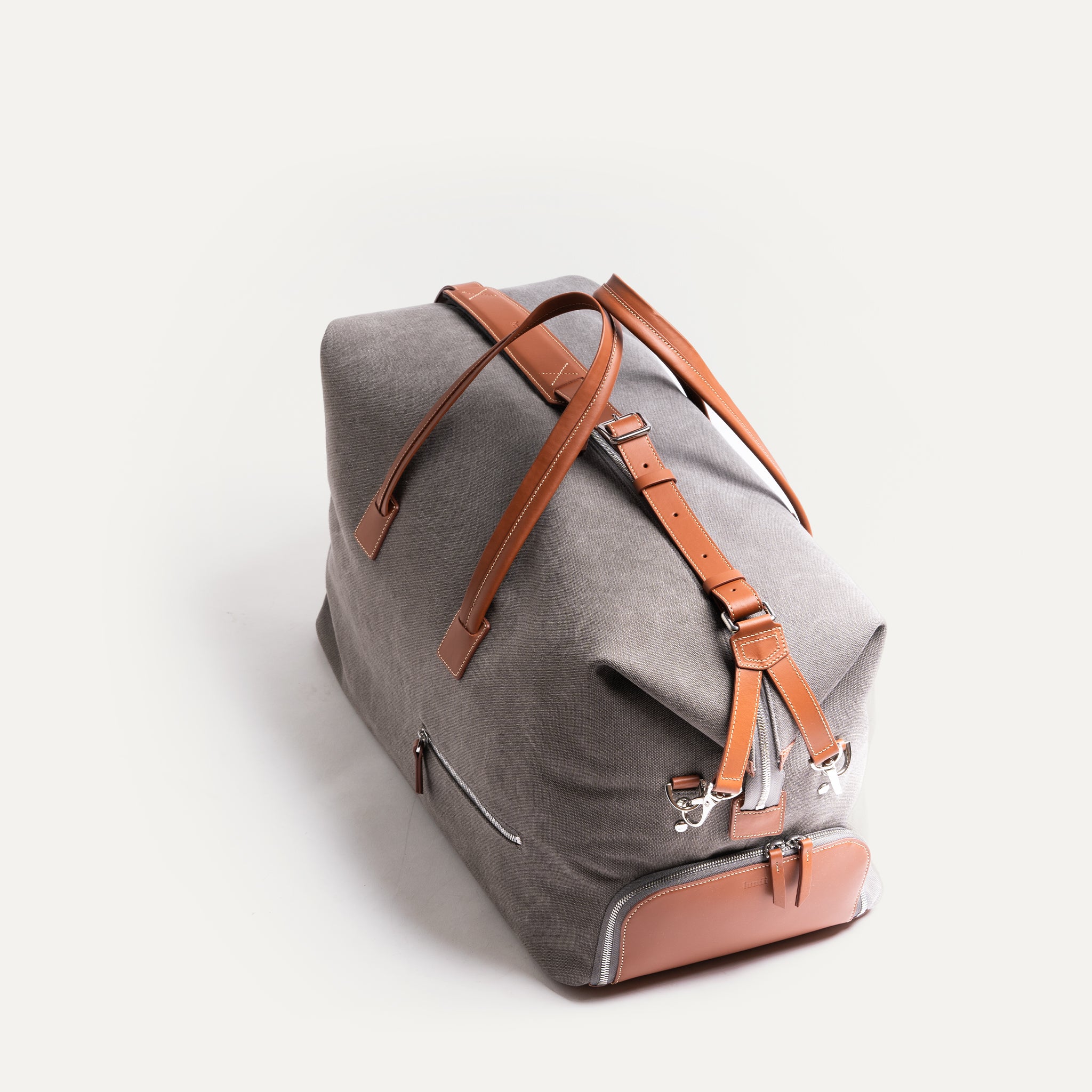 Ce sac de voyage gris et camel offre un espace de rangement pratique pour tous vos essentiels de voyage. Les poches latérales permettent un accès facile à vos objets personnels.  Fabriqué avec le plus grand soin, ce sac de voyage gris et marron est un gage de qualité. Son cuir de haute qualité et sa finition impeccable en font un choix de premier ordre.